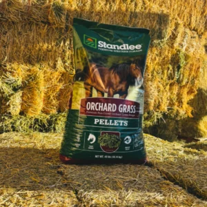 Bag of Orchard Grill Pellets by Scandbee in front of stacked straw bales.