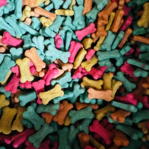 Colorful dog bone-shaped treats scattered together.