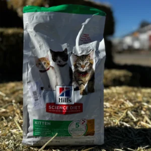 A bag of Hill's Science Diet cat food outdoors on hay.