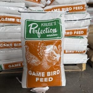 A bag of Kruse's Reflections game bird feed displayed in front of stacked bags.