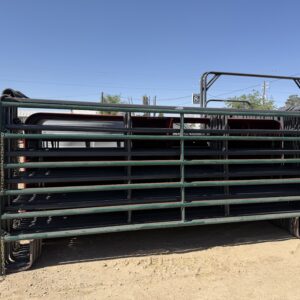 Large black metal livestock panels stacked outdoors on a sunny day.