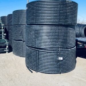Stacks of large black industrial pipes outdoors.