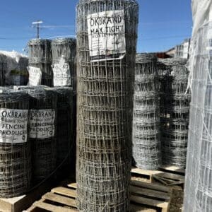 Rolls of wire fencing stacked outdoors on pallets.