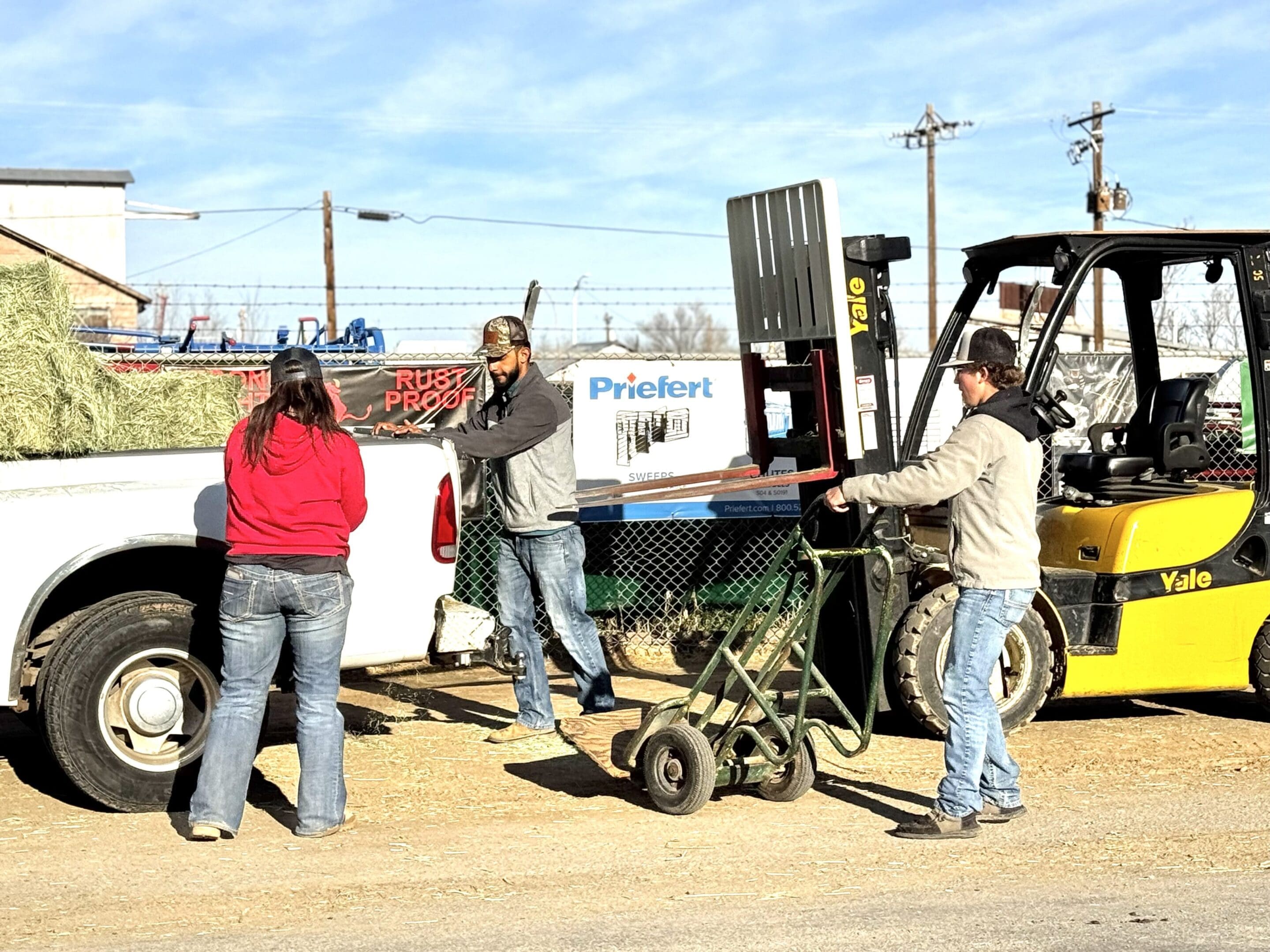 People discussing near construction equipment on a sunny day.